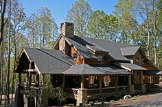 a large house with a tall chimney in the woods