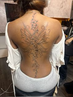 the back of a woman's body with flowers on her upper and lower back