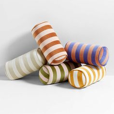 five striped vases stacked on top of each other in the shape of cones, all different colors and sizes