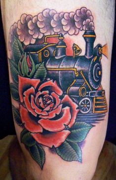 a tattoo on the leg of a person with a train and rose in front of it