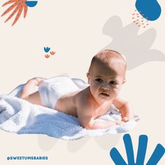 a baby laying on top of a white blanket next to blue and orange hand prints