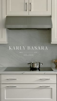 a kitchen with white cabinets and marble counter tops, including a stainless steel range hood