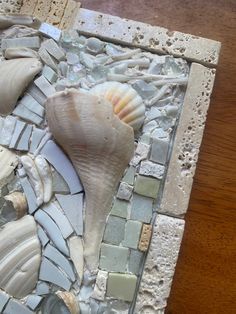 there is a sea shell on the mosaic tile