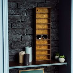 a book shelf with sunglasses on top of it next to a sign and potted plant