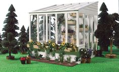 a miniature garden shed with potted plants and flowers