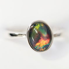 Rhodium Plated Silver Ring-Opal Triplet Polished Opal Oval Cabochon Ring, Polished Opal Ring In Oval Cabochon Shape, Opal Oval Cabochon Ring With Polished Finish, Modern Oval Opal Ring, Modern Round Opal Ring, Silver Opal Ring With Oval Cabochon, Iridescent Opal Ring In Sterling Silver For Anniversary, Iridescent Opal Ring With Gemstone, Modern Opal Ring For Anniversary