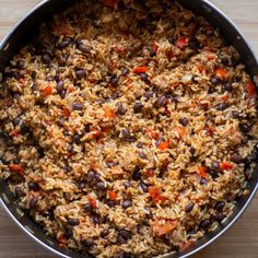 a pot filled with rice and beans on top of a wooden table