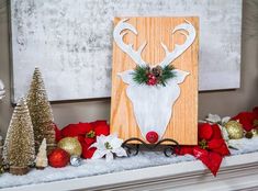 a decorated mantle with christmas decorations and deer's head painted on the front side