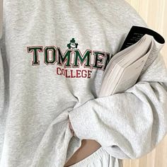 a person wearing a sweatshirt with the word tomme college printed on it's chest