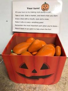 a box filled with oranges sitting on top of a counter next to a sign