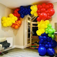 the balloon arch is decorated with multicolored balloons