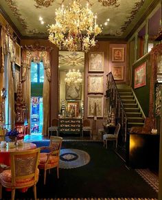 an ornately decorated dining room with chandelier and paintings on the wall above it