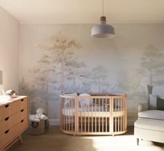 a baby's room with a crib, dresser and wallpaper in the background