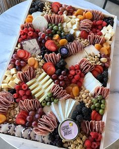 a platter filled with cheese, fruit and crackers