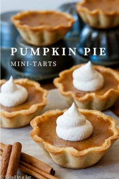 mini pumpkin pies with whipped cream on top and cinnamon sticks in the foreground