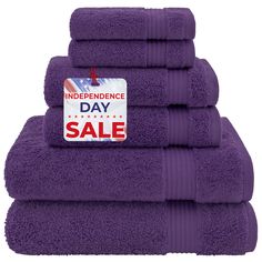 purple towels stacked on top of each other with a sale tag attached to the front