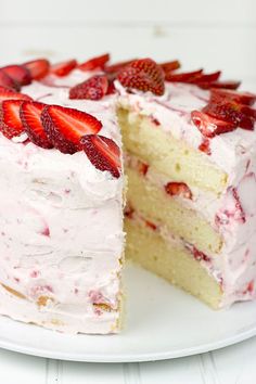 there is a piece of cake with strawberries on it and the rest of the cake has white frosting