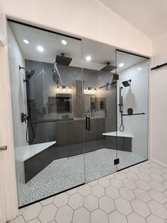 a bathroom with glass doors and tiled flooring in front of the shower area is shown