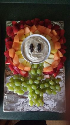 a platter with fruit and dip on it