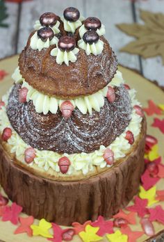 a three tiered cake with frosting and decorations on the top is sitting on a plate