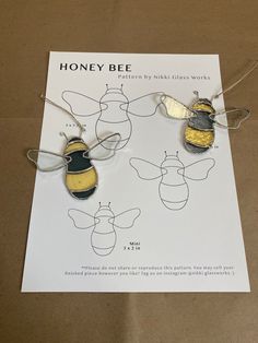 three bees are shown on a piece of paper with string attached to them, and one is