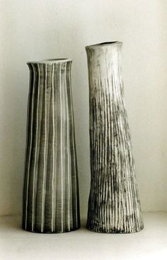 two black and white vases sitting next to each other