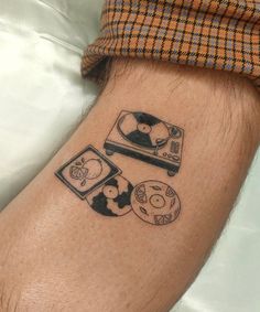 a man with a tattoo on his arm has a record player and other items around him