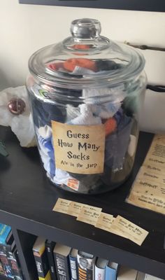 a glass jar filled with candy sitting on top of a book shelf next to a pile of books