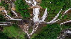 an aerial view of waterfalls in the forest