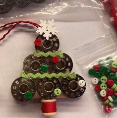 a christmas tree ornament made out of buttons and other crafting supplies sitting on a table