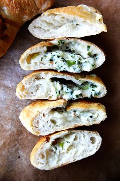 four pieces of bread with cheese and herbs on them