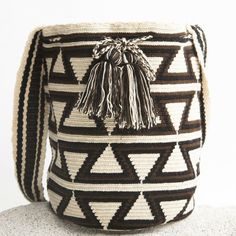 a black and white bag with tassels on it