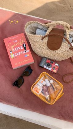 the contents of a beach bag sitting on top of a table next to a book