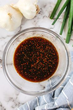 the ingredients to make this dish are in a glass bowl, including green onions and seasoning