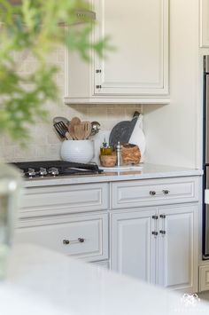 a kitchen with white cabinets and black appliances