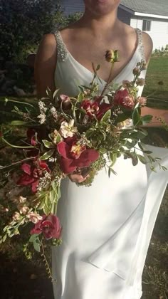 a woman in a white dress holding a bouquet of flowers