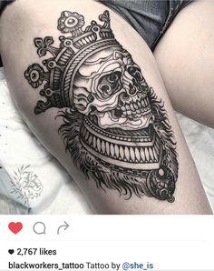 a woman's thigh with a skull and crown tattoo on it