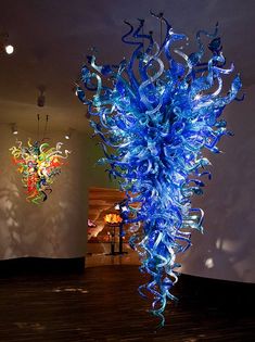 a blue glass sculpture sitting on top of a wooden floor