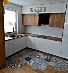 an empty kitchen with wooden cabinets and tile flooring on the walls, along with a window