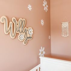 a baby's room decorated in pink and white with flowers on the wall, crib