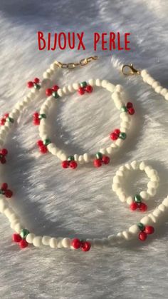 a white beaded necklace and bracelet with red beads