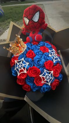 a spiderman bouquet made out of red, white and blue roses is sitting on top of a cardboard box