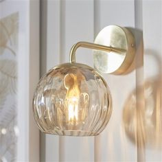 a wall light that is on the side of a wall next to a curtained window