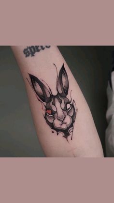 a black and white rabbit tattoo on the arm