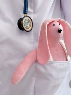 a pink stuffed animal is in the pocket of a doctor's white lab coat