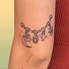 a woman's arm with a chain and stars tattoo on the side of her leg