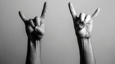 two hands making the v sign with their fingers in black and white photo against a gray background