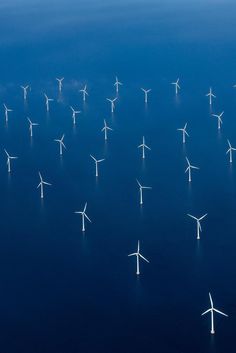 an aerial view of wind turbines in the ocean