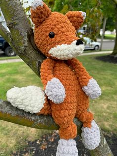 a crocheted stuffed animal sitting on top of a tree branch