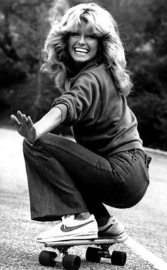 an old photo of a woman riding a skateboard